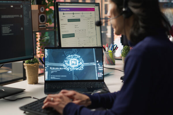 Person working on multiple computer screens.